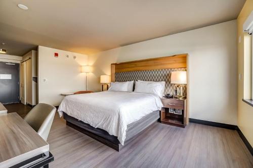 a hotel room with a large bed and a table at Holiday Inn Gatineau - Ottawa by IHG in Gatineau
