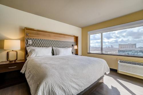 a bedroom with a large bed and a large window at Holiday Inn Gatineau - Ottawa by IHG in Gatineau