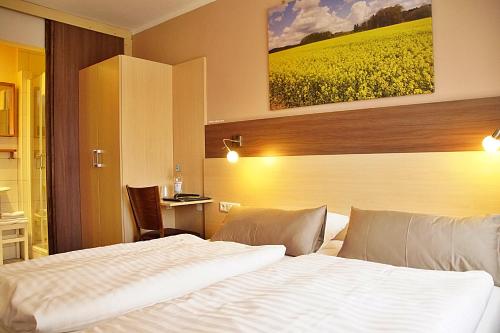 a hotel room with a bed and a yellow field at Hotel Eifelstube in Rodder
