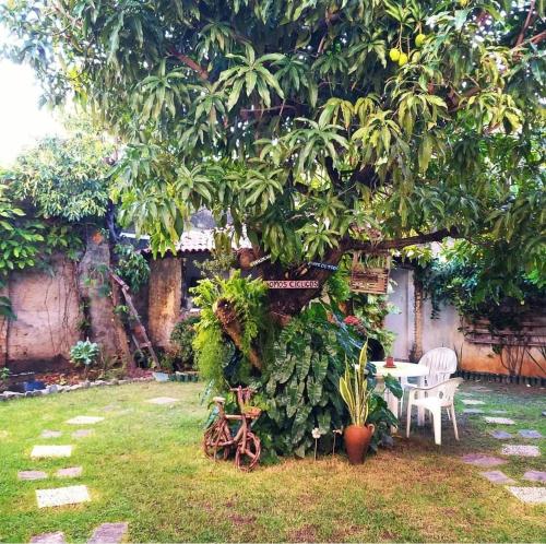 a garden with a table and chairs under a tree at Refúgio da Mangueira in Barra dos Coqueiros
