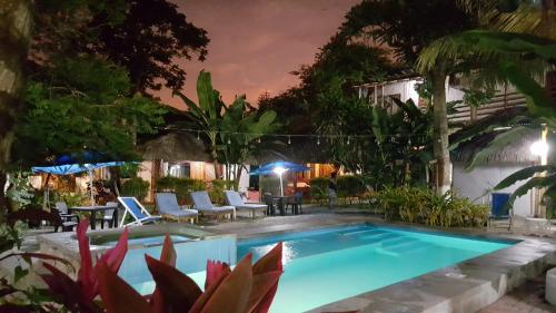 a swimming pool in a yard at night at Hotel Sumpa in Montañita