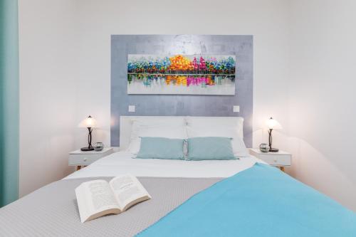 een slaapkamer met een bed met 2 boeken en 2 lampen bij Apartment Mila in Fažana