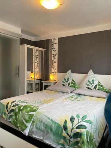 ein Schlafzimmer mit einem großen Bett mit einer tropischen Tagesdecke in der Unterkunft Haus Übernachtenswert Cochem Mosel in Cochem
