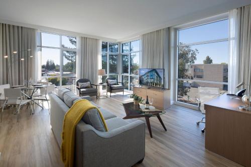a living room with a couch and a tv and a table at Art House Hotel in Santa Rosa