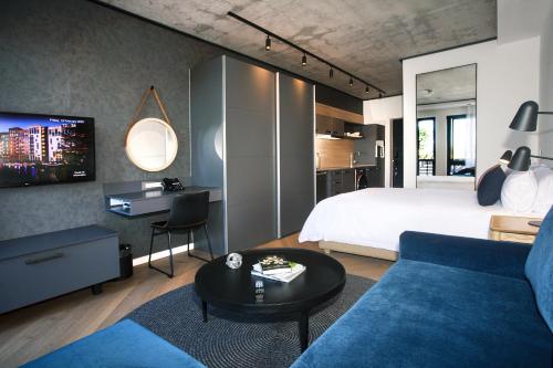 a bedroom with a bed and a blue couch at Bridgewater Apartments by Century City Hotels in Cape Town