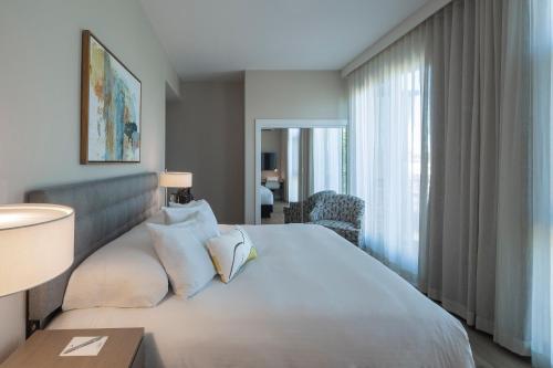 a hotel room with a large white bed and a window at Art House Hotel in Santa Rosa
