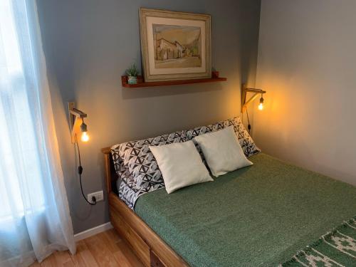 ein kleines Schlafzimmer mit einem Bett mit zwei Lampen in der Unterkunft Casa Olavarria in San Salvador de Jujuy