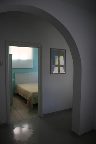 an archway leading to a bedroom with a bed at Apartment Nola in Porozina