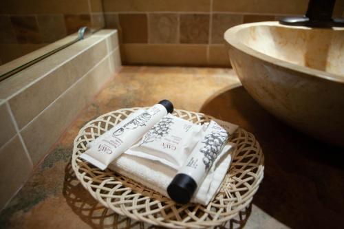 a basket with two towels and a sink in a bathroom at Encanto de la Sierra Hotel in Mascota