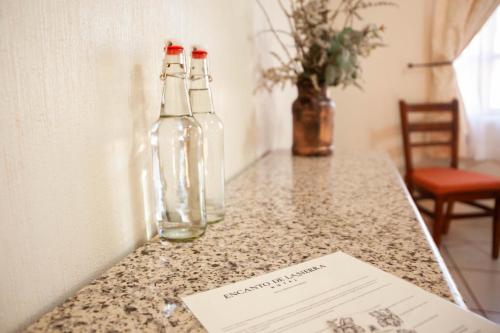 two glass bottles sitting on top of a counter at Encanto de la Sierra Hotel in Mascota