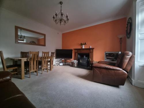 a living room with a couch and a table and chairs at Rose Cottage City Centre in Inverness