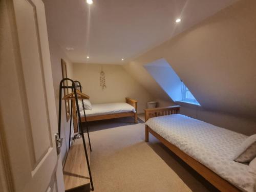 a attic room with two beds and a ladder at Rose Cottage City Centre in Inverness