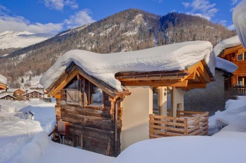 
a wooden cabin with a snow covered mountain at Chalet Alpoase in Zermatt
