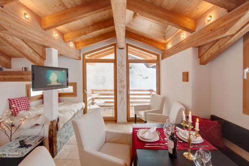 ツェルマットにあるChalet Alpoaseの木製の天井と大きな窓が備わるリビングルーム