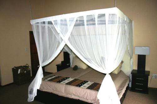 a bedroom with a canopy bed with white curtains at River House in Mica