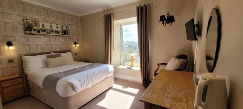 a bedroom with a large bed and a window at The Mortal Man Inn in Troutbeck