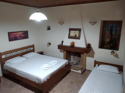- une chambre avec 2 lits et une cheminée dans l'établissement "studiosKALITHEA", à Porto Heli