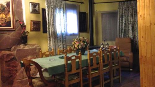 d'une table à manger avec des chaises et un vase de fleurs. dans l'établissement Encanto de Aragón, à Torres de Albarracín