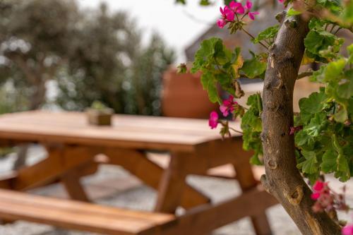 a wooden picnic table with pink flowers on it at Maistros Villa in Rodakino