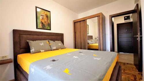 ein Schlafzimmer mit einem großen Bett mit einer gelben Decke in der Unterkunft Aleksa Lux apartment Budva in Budva
