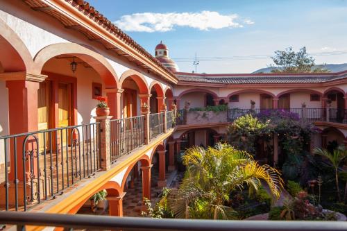 an old building with a balcony and plants at Encanto de la Sierra Hotel in Mascota