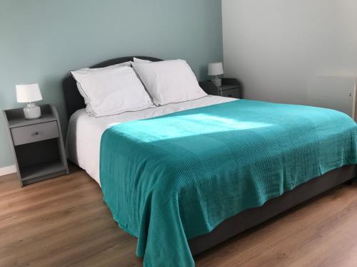 une chambre avec un lit avec une couverture verte dessus dans l'établissement APPARTEMENT NEUF ET BIEN SITUE AVEC UN CLASSEMENT, à Saint-Malo