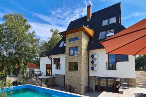a house with a swimming pool in front of it at Mihelyünk in Fonyód