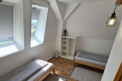 um pequeno quarto branco com uma cama e 2 janelas em Mihelyünk em Fonyód