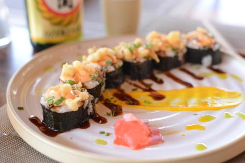 a plate of food with sushi on a table at El Ben Cabañas in Caye Caulker