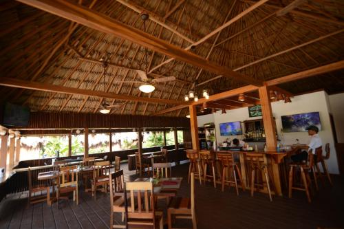 a restaurant with wooden chairs and tables and a bar at El Ben Cabañas in Caye Caulker