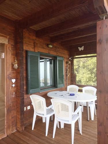 a porch with a white table and white chairs at CHALET REGINA in Paradhísion