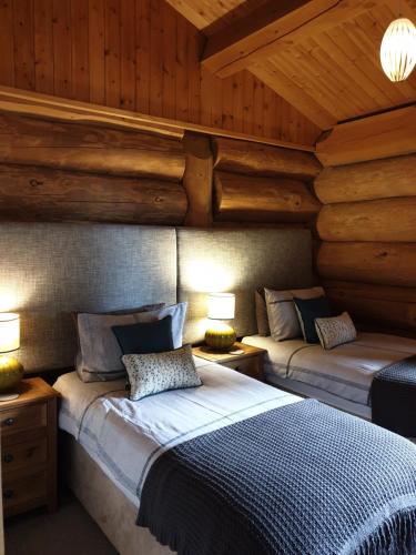 a bedroom with two beds in a log cabin at Newland Valley Log Cabins in Ulverston