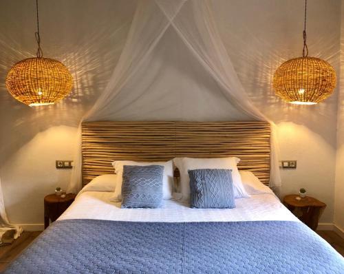 1 dormitorio con 1 cama con 2 almohadas azules en La Lolita ( Adults Only ), en Sant Martí Vell