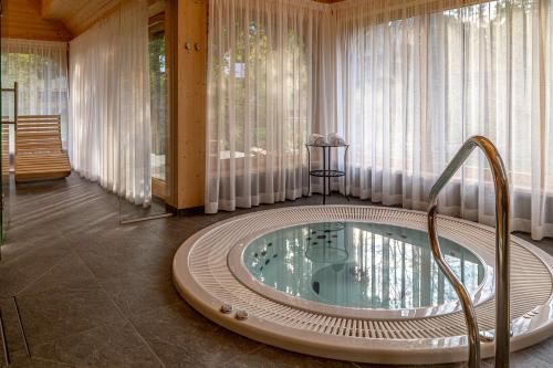 una vasca idromassaggio in una stanza con tende di Willa Elżbiecina Luxury Residence & SPA a Zakopane