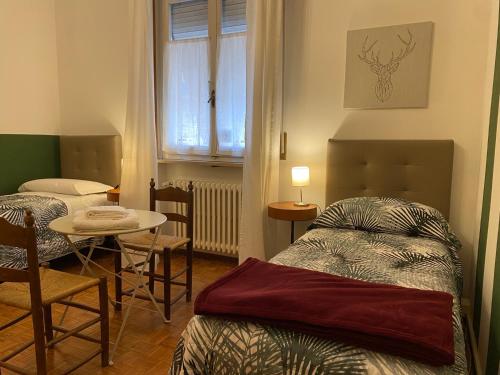 a bedroom with a bed and a table and a window at Affittacamere Room ospedale Maggiore in Parma