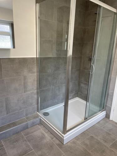 y baño con ducha y mampara de cristal. en Modern House In Stoke on Trent, en Stoke on Trent