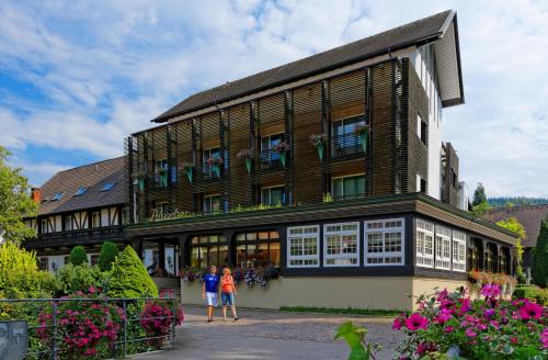 two people standing in front of a building at Hotel Hirschen in Glottertal