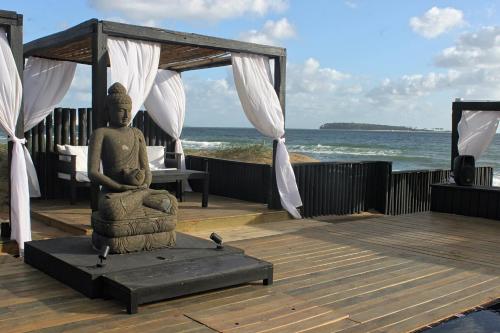 a statue on a deck with the ocean in the background at Serena Hotel - Punta del Este - Unico sobre la Playa in Punta del Este