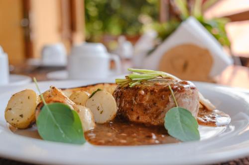 a plate of food with meat and potatoes on a table at Argovia Ecolodge in Tapachula