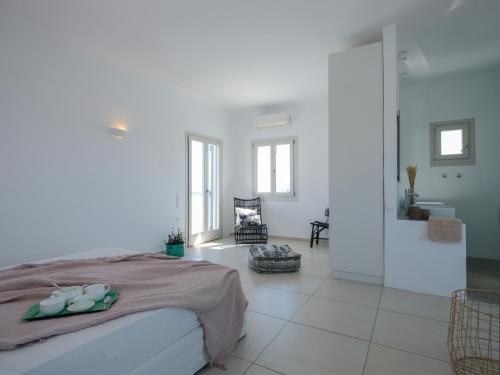 a white bedroom with a bed and a bathroom at Secret Island in Tourlos