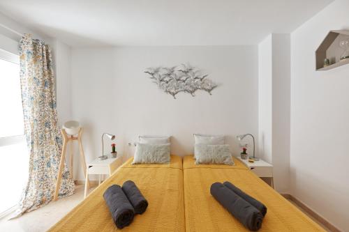 um quarto com uma cama amarela com duas almofadas em Penthouse Cactus Old Center em Alicante