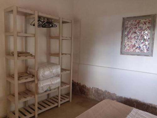 a room with wooden shelves and a painting on the wall at Casa Inkill Huasi in Tilcara