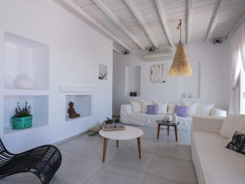 a white living room with a couch and a table at Secret Island in Tourlos