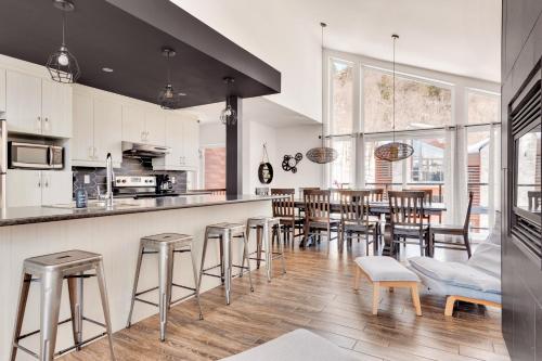 a kitchen and dining room with a bar and stools at 25- Chalet à Louer à Stoneham in Stoneham