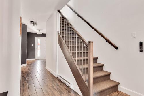 a staircase in a home with white walls and wooden floors at 25- Chalet à Louer à Stoneham in Stoneham