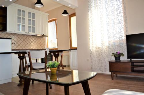 a living room with a table and a tv at Chola Guest House in Bitola