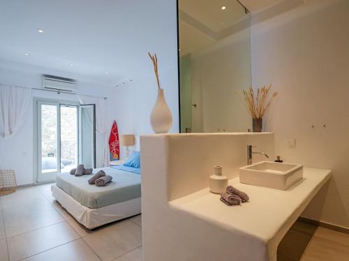 a bathroom with a sink and a bed in a room at Secret Island in Tourlos