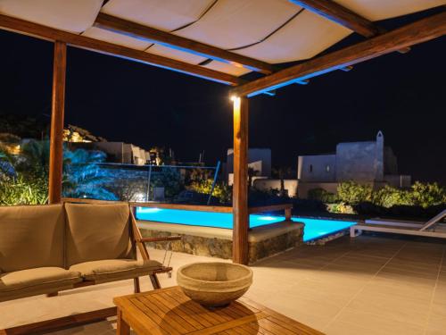 a patio with a chair and a table and a pool at Secret Island in Tourlos