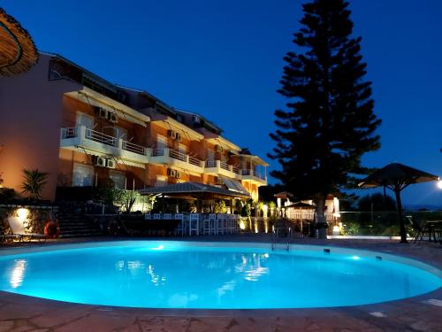 a swimming pool in front of a hotel at night at Stefanosplace ApartHotel Sea View in Barbati