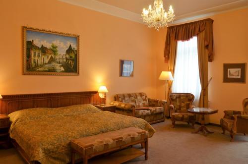 um quarto com uma cama e um lustre em Bristol Georgy House em Karlovy Vary